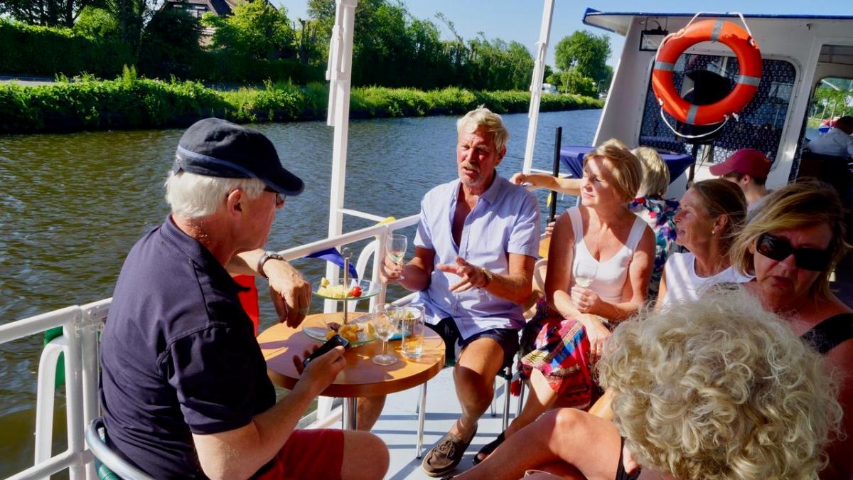 Six people sitting on a table on a boat