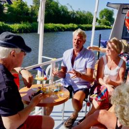 Six people sitting on a table on a boat