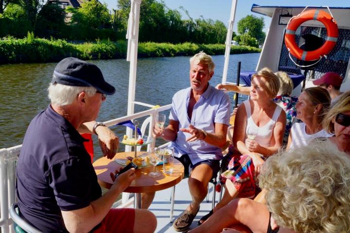 Six people sitting on a table on a boat
