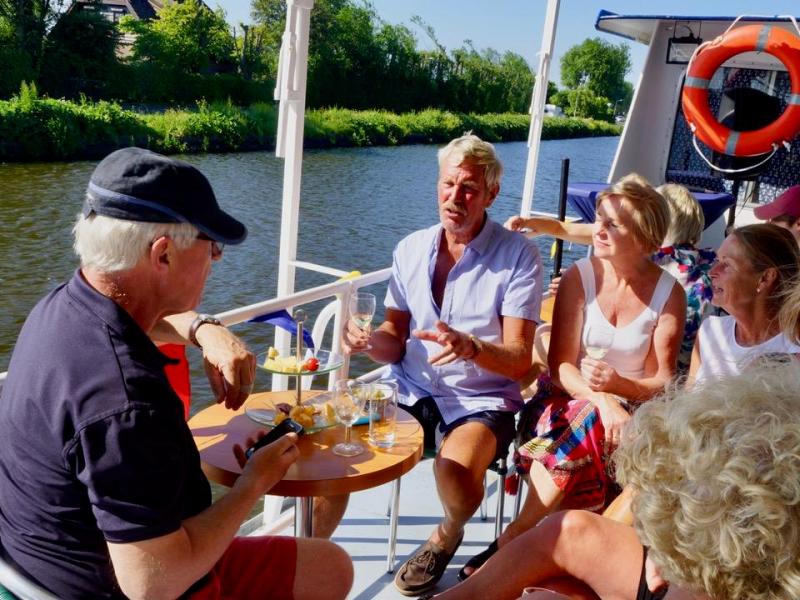 Six people sitting on a table on a boat