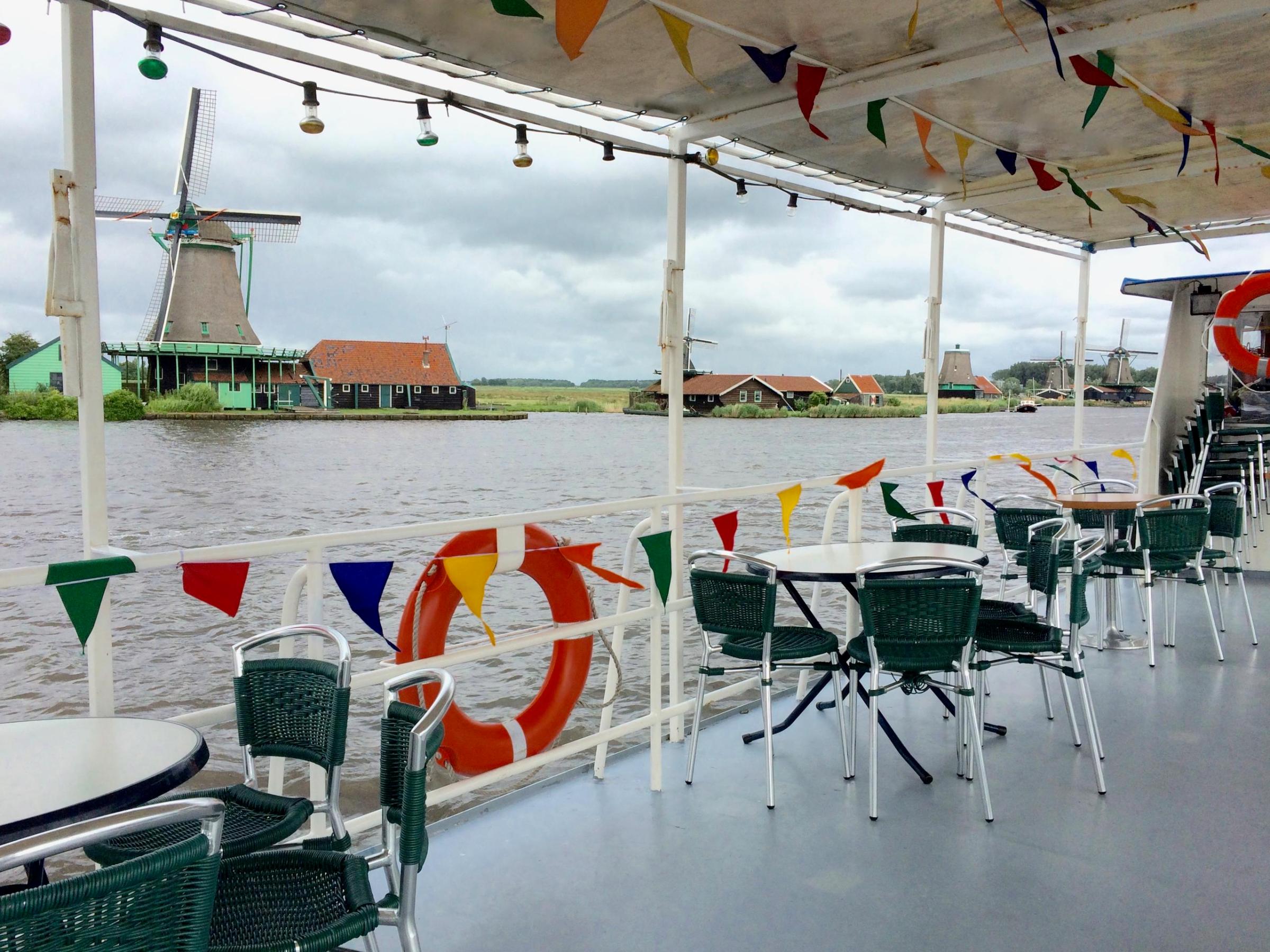 Some empty tables and chairs on the deck of the boat