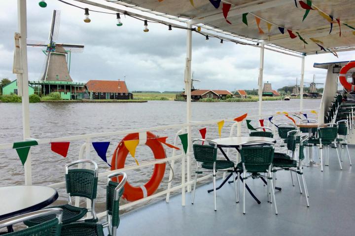 Some empty tables and chairs on the deck of the boat