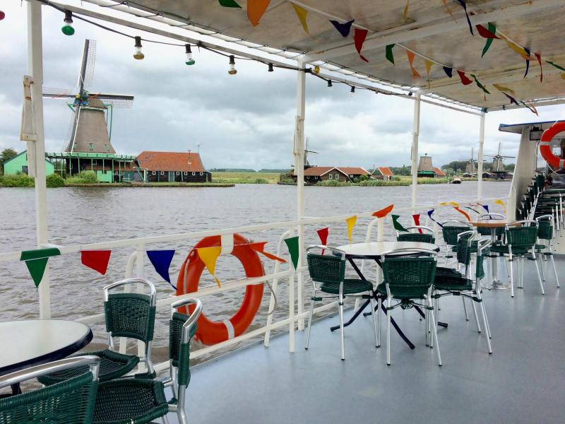 Some empty tables and chairs on the deck of the boat