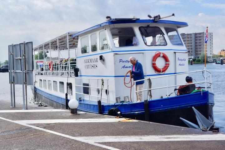A man holding a rope in his hands standing on the boat