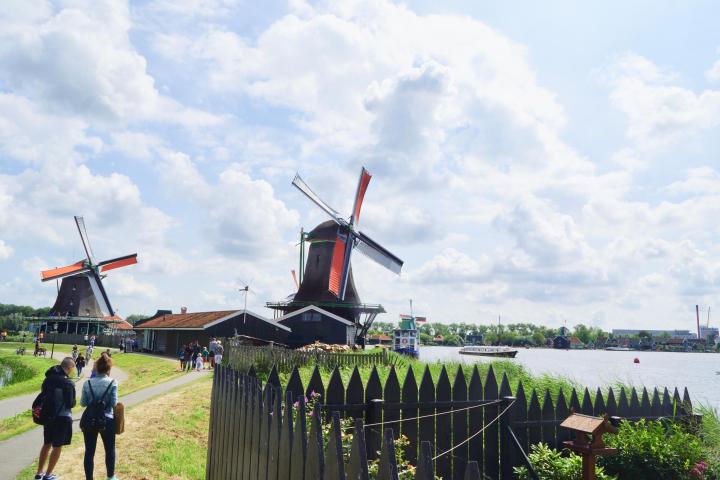 Three windmills at Zaanse Schans and people walking next to them