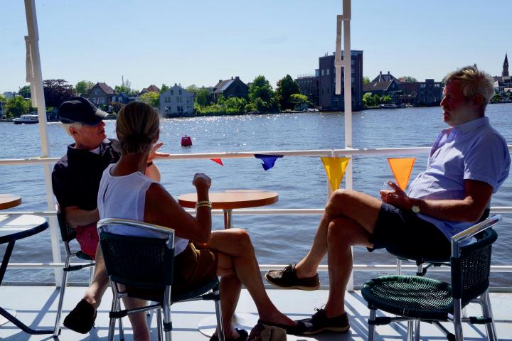 Three people sitting at a table on the boat