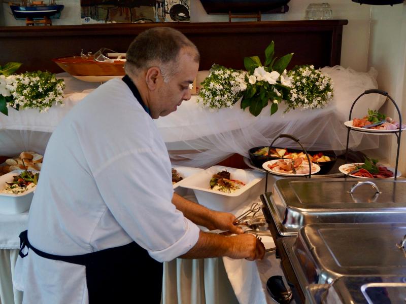 A cook arranging a buffet on the inside of the boat