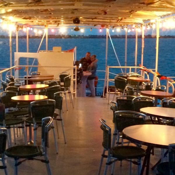 A man hugging a woman on the deck of the boat at night
