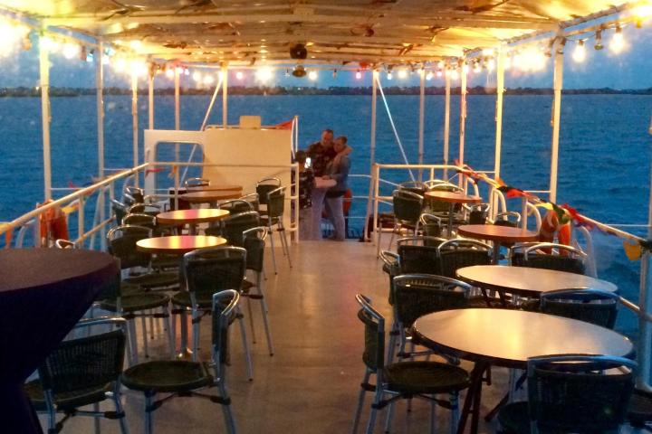 A man hugging a woman on the deck of the boat at night