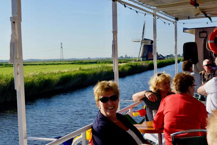 A woman smiling and sitting on the deck of the boat