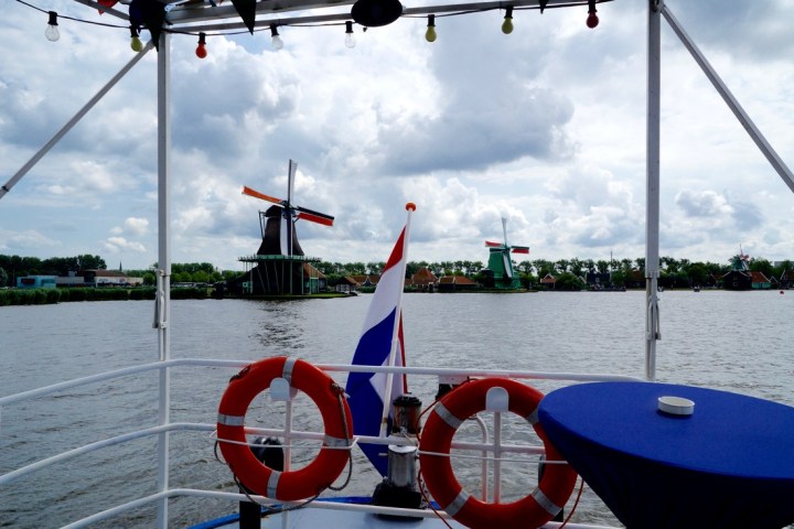 The back of the boat with two lifebelts and the Dutch flag attached at the back of the boat
