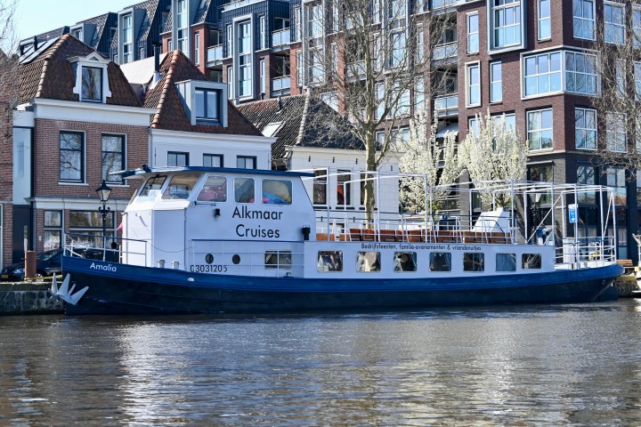 a large boat in a body of water with a city in the background